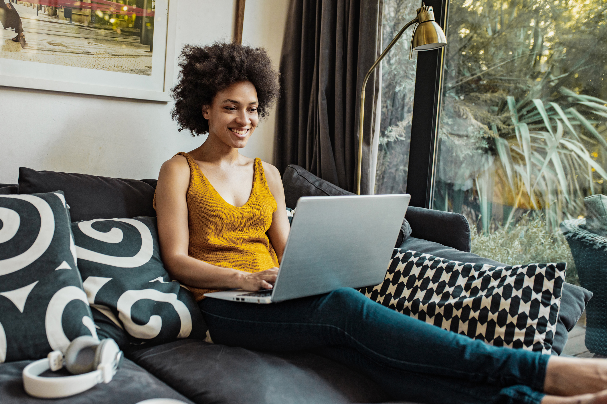 A mixed-race woman is using a laptop and working from home